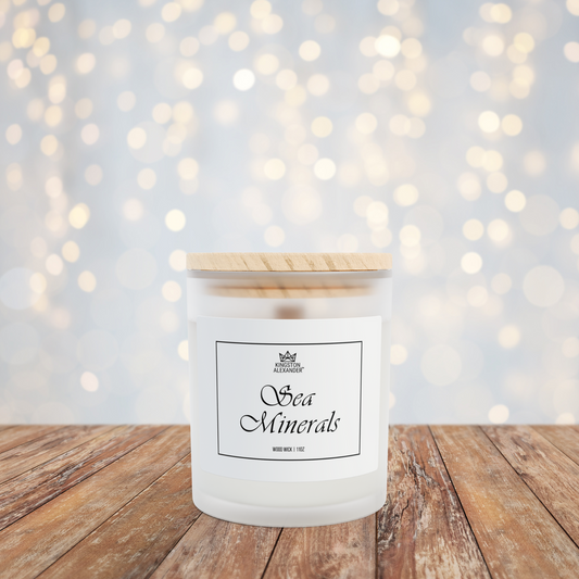 Candle labeled 'Sea Minerals' on a wooden surface with a softly blurred bokeh background